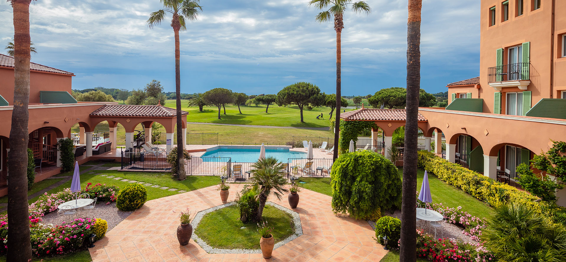 Vista desde la terraza privada de la habitación Golf Vista del Palmyra Golf, la piscina, el campo de golf y el jardín. Palmyra Golf, hotel de 4 estrellas en Cap d'Agde