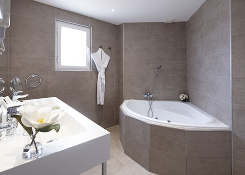 Bathroom with bathtub in the suite at the Palmyra Golf, 4-star hotel in Occitanie
